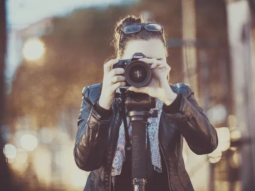 Photographer holds camera and takes a photo in the city.