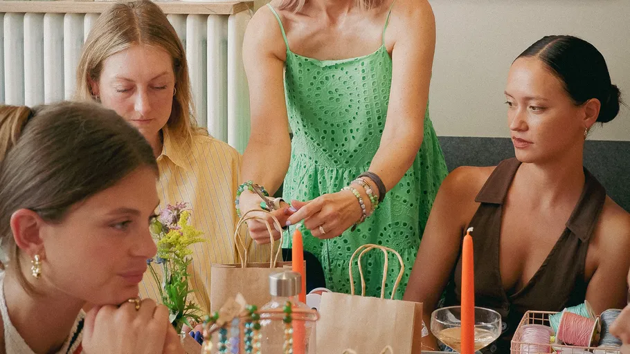 Women crafting at a table with candles.