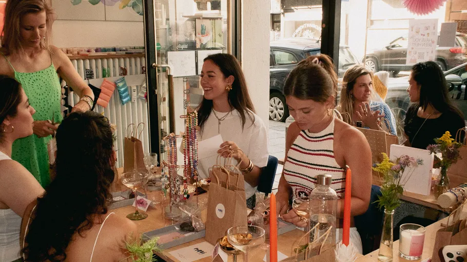 Women crafting jewelry in a cozy shop.