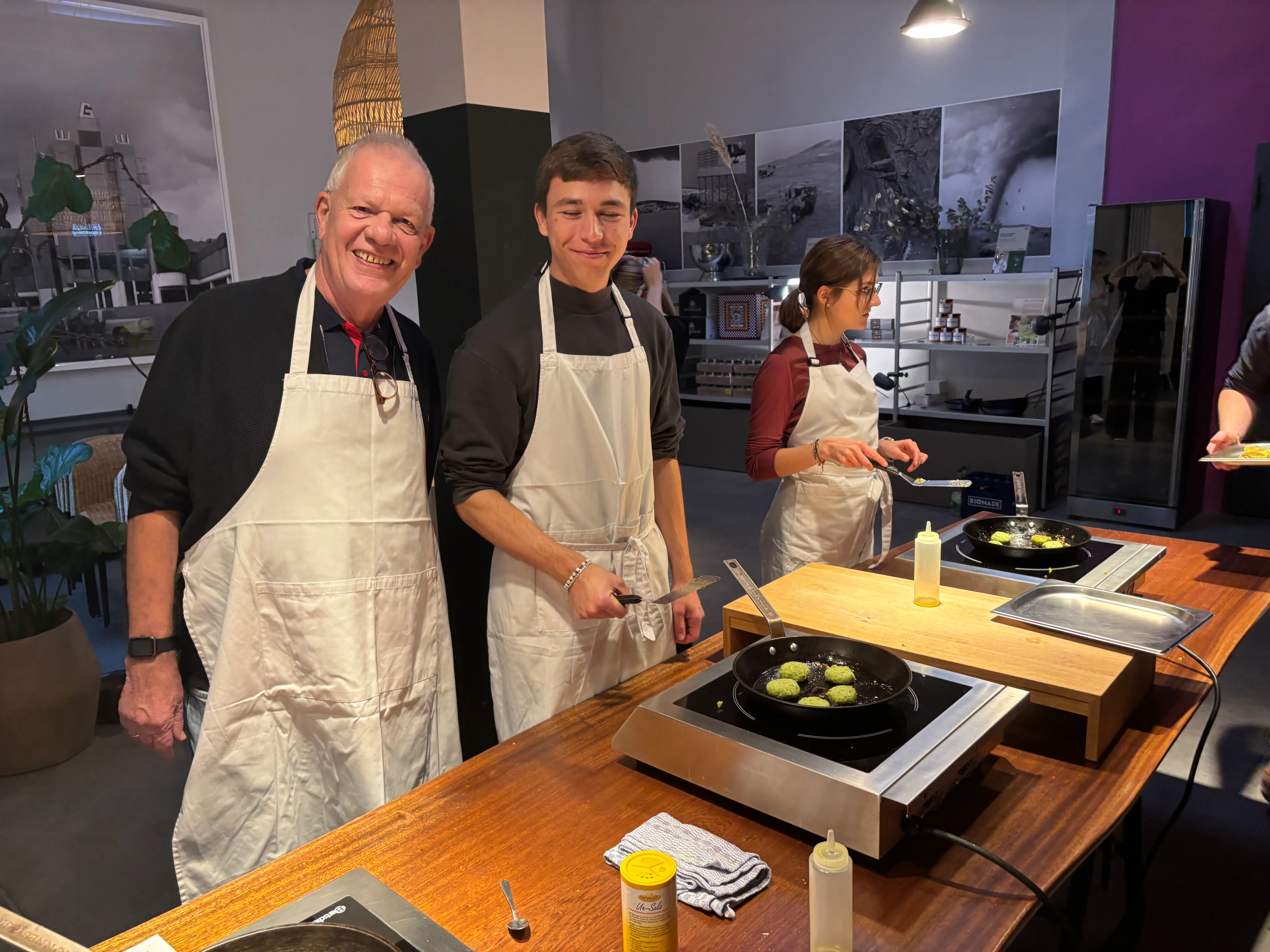 Drei Personen kochen in einem Küchenstudio.
