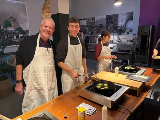Three people cooking in a kitchen studio.