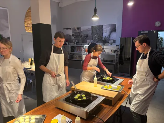 Four people cooking together in a kitchen.