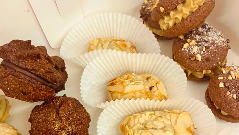 Assorted cookies in paper cups on tray.