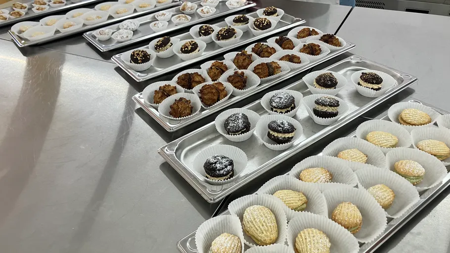 Cookies arranged on trays in a kitchen.