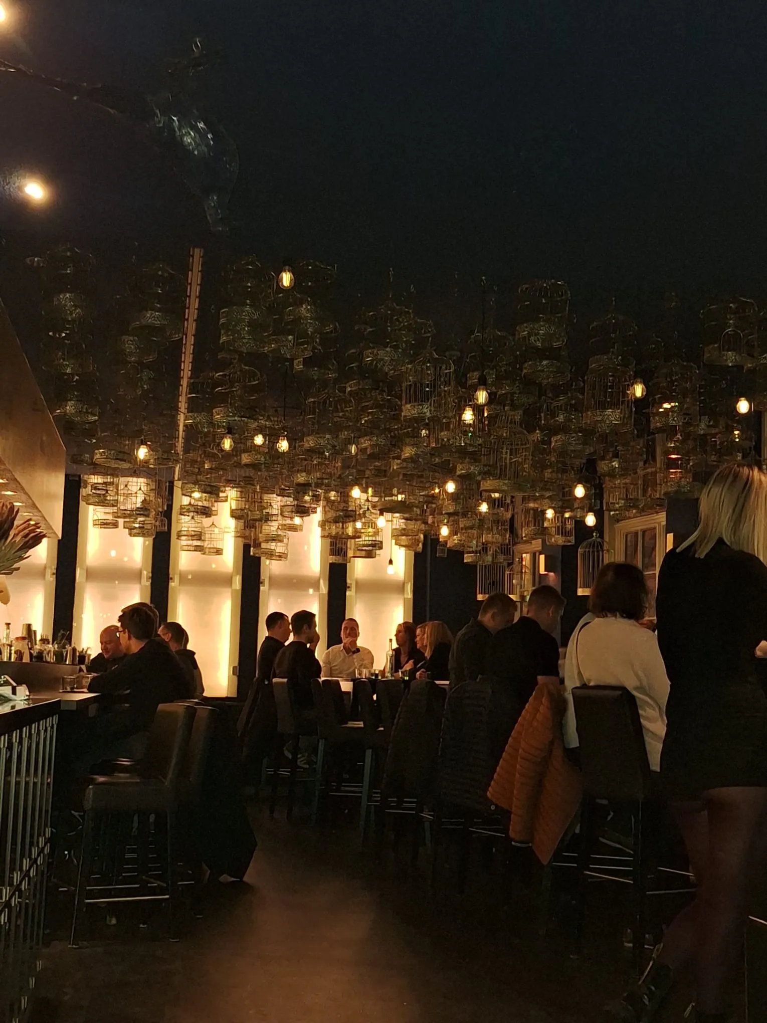 Menschen essen in schwach beleuchtetem Restaurant.