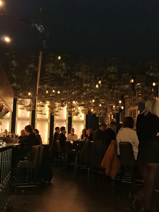 Menschen essen in schwach beleuchtetem Restaurant.