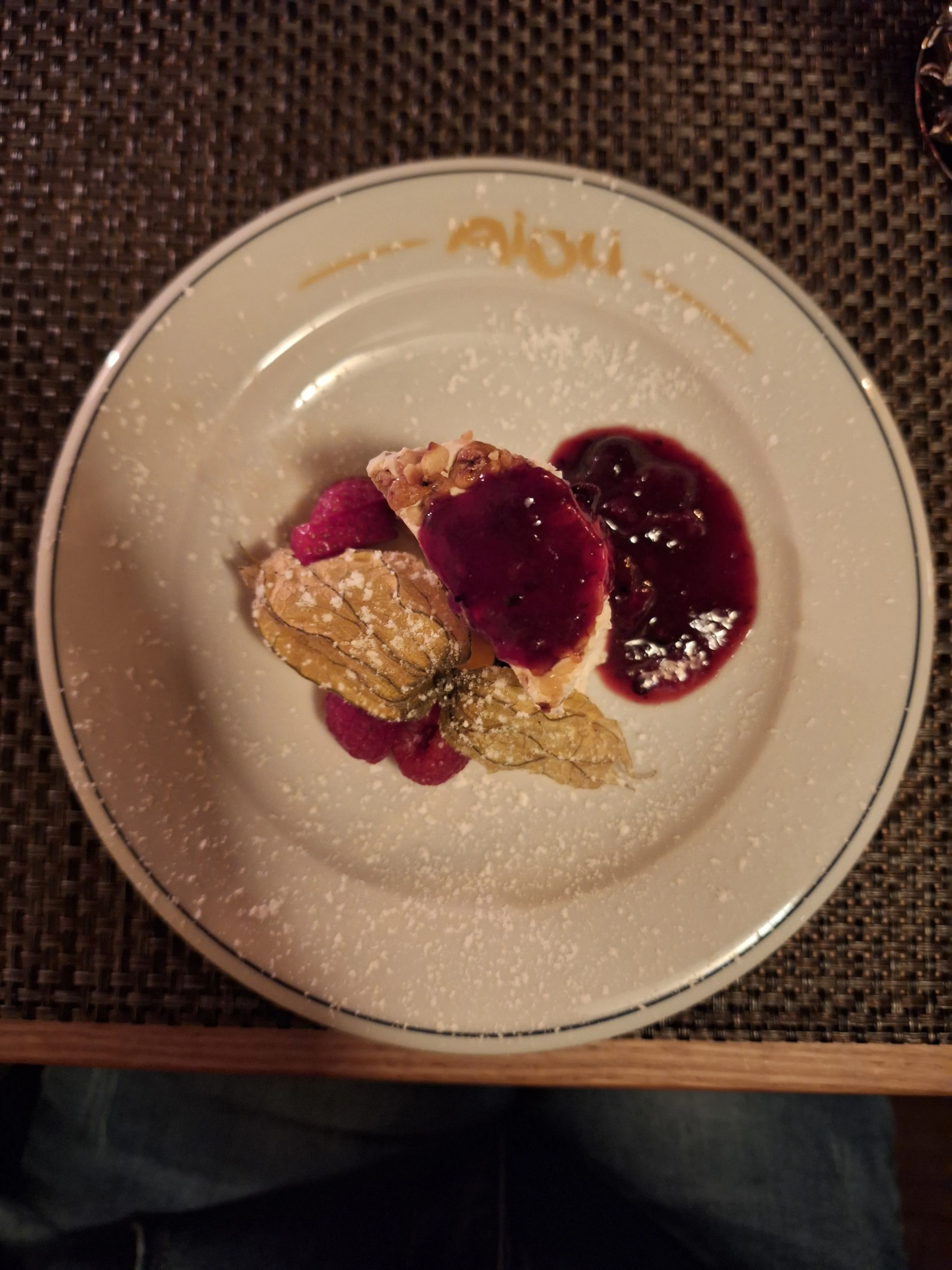 Dessert mit Beerensauce auf weißem Teller.