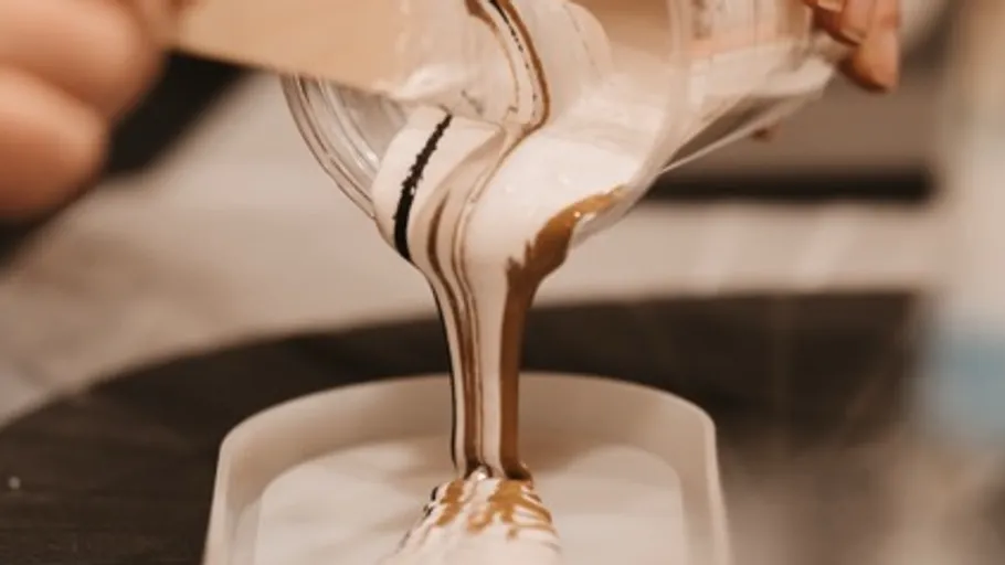 Pouring layered liquid into mold, close-up.