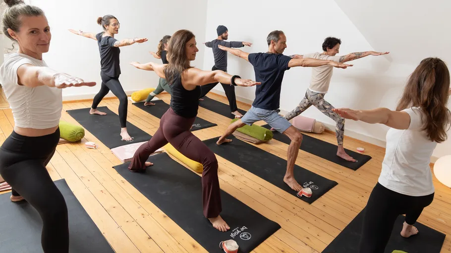Group practicing yoga in studio on mats.