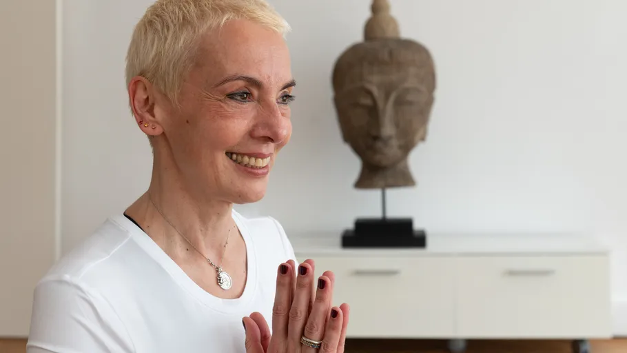 Smiling woman practicing yoga in home.