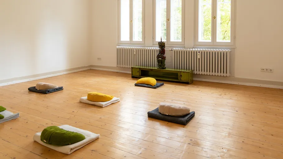 Meditation cushions arranged in bright room.