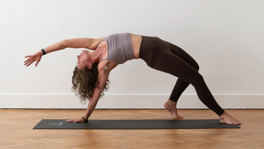 Woman doing yoga pose on mat indoors.