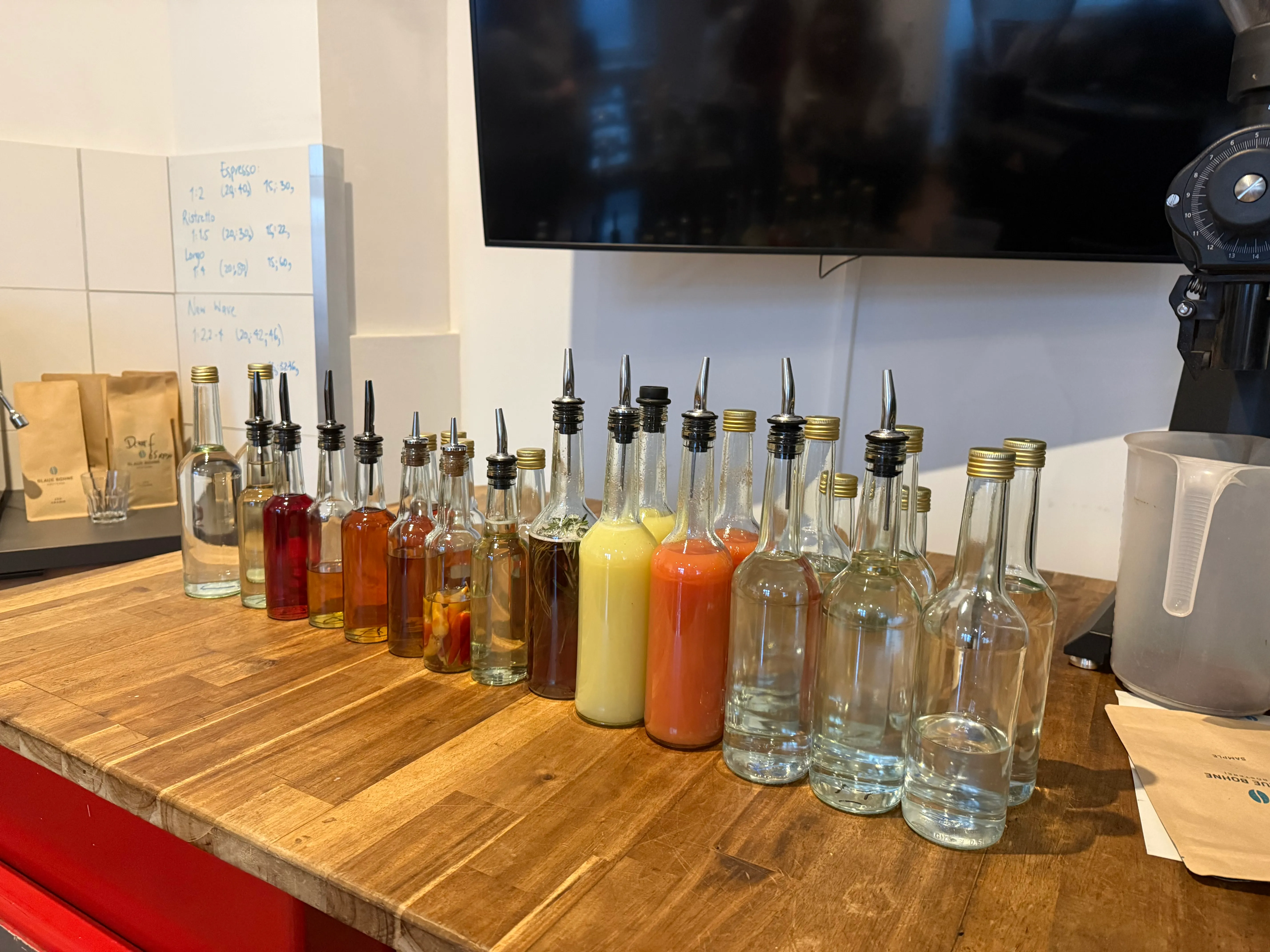 Bottles with spouts on wooden counter.