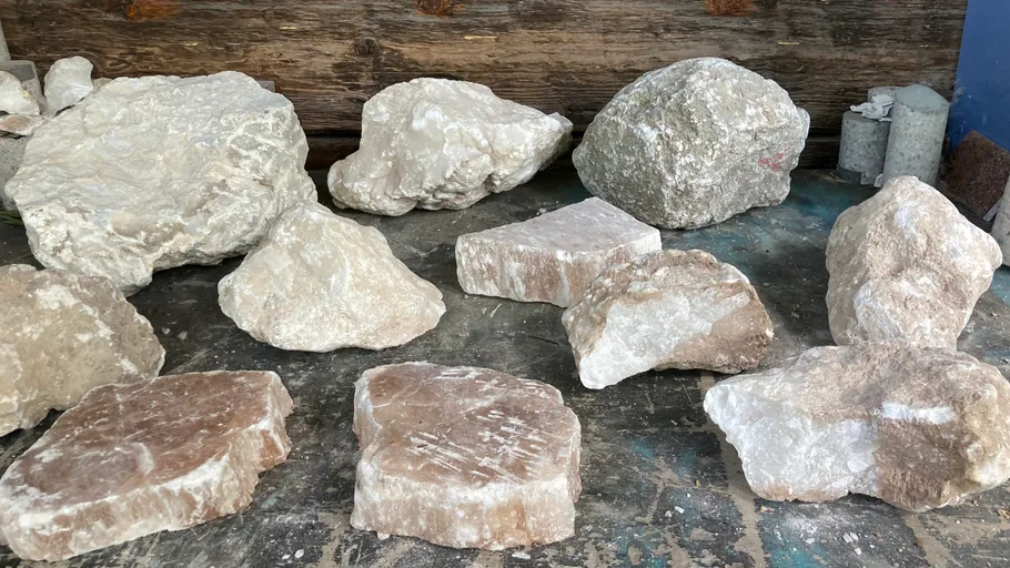 Several large rocks displayed on a floor.