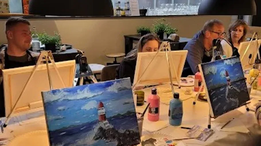 People painting coastal scenes in art class.