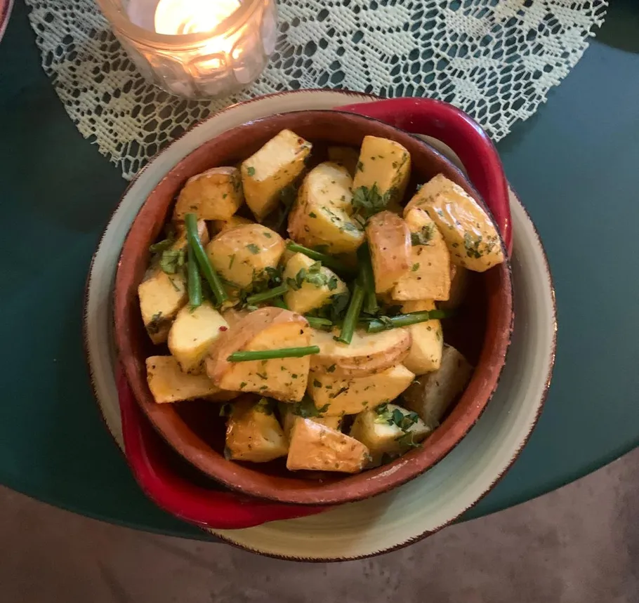 Herb-roasted potatoes in bowl on table.