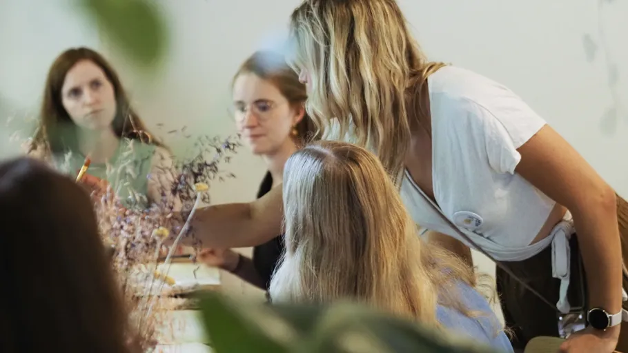 Frau leitet kreativen Workshop mit Teilnehmern.