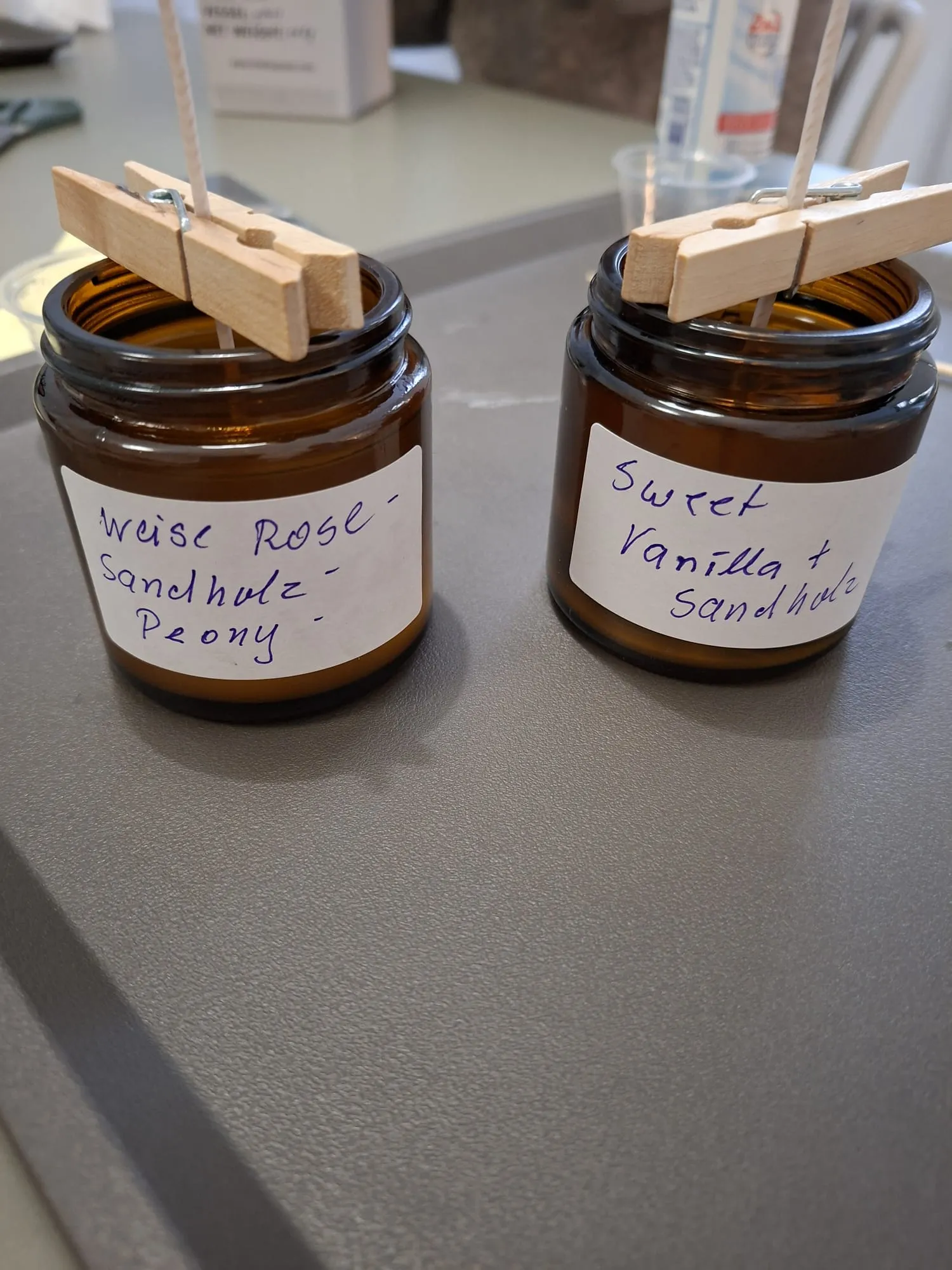 Zwei Kerzengläser mit Duftetiketten.