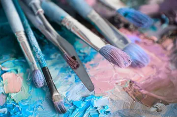 Pinsel mit Pastellfarben auf Palette.