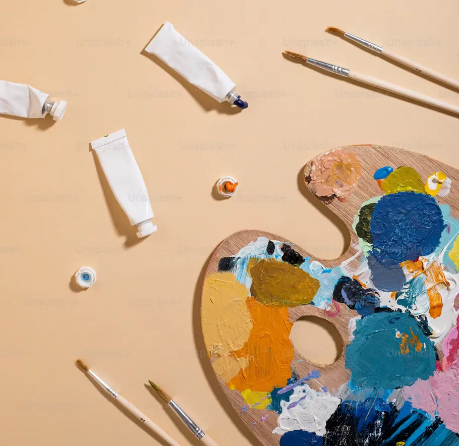 Farb Tuben, Pinsel, Palette auf beigem Hintergrund.