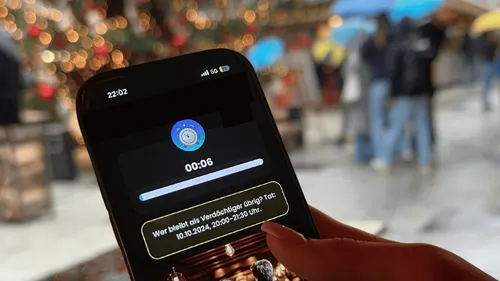 Smartphone with timer in outdoor festive setting.