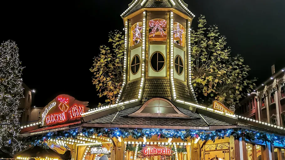 Weihnachtsmarktstand mit beleuchteten Dekorationen.