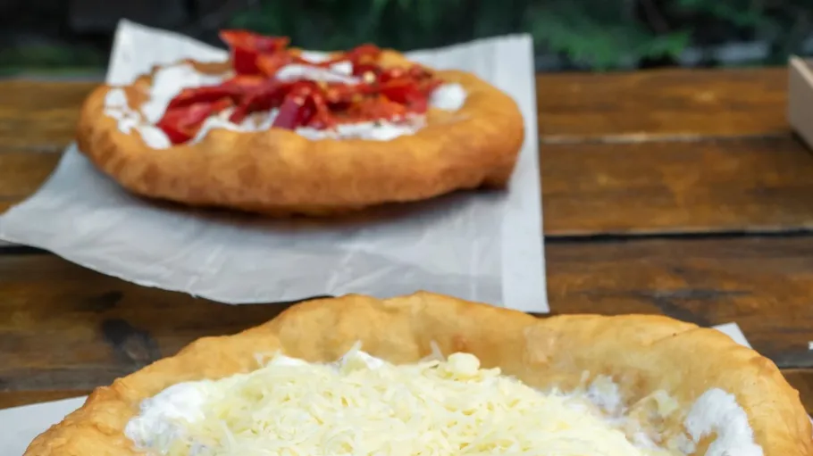 Fried dough with cheese and cream on table.