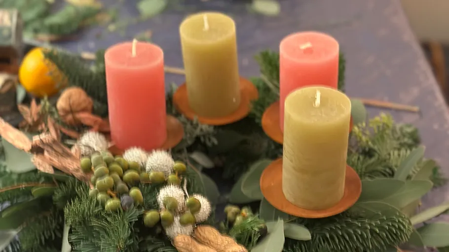 Four candles on decorative Christmas wreath.