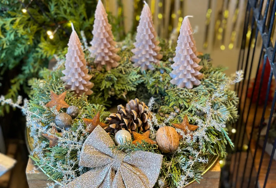 Adventskranz mit Kerzen und Weihnachtsdekorationen.