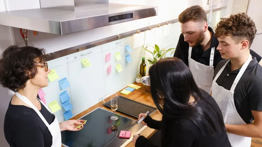 Group discussing with sticky notes in kitchen.