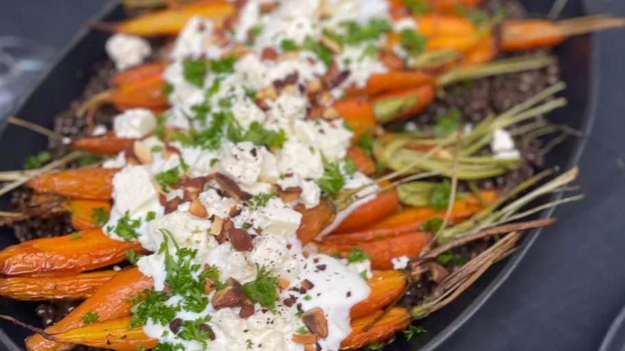 Roasted carrots with cheese, nuts, herbs garnish.