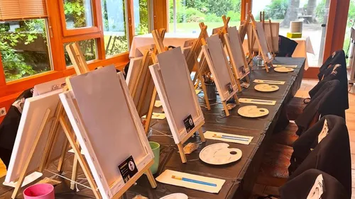 Easels with canvases arranged in a room.