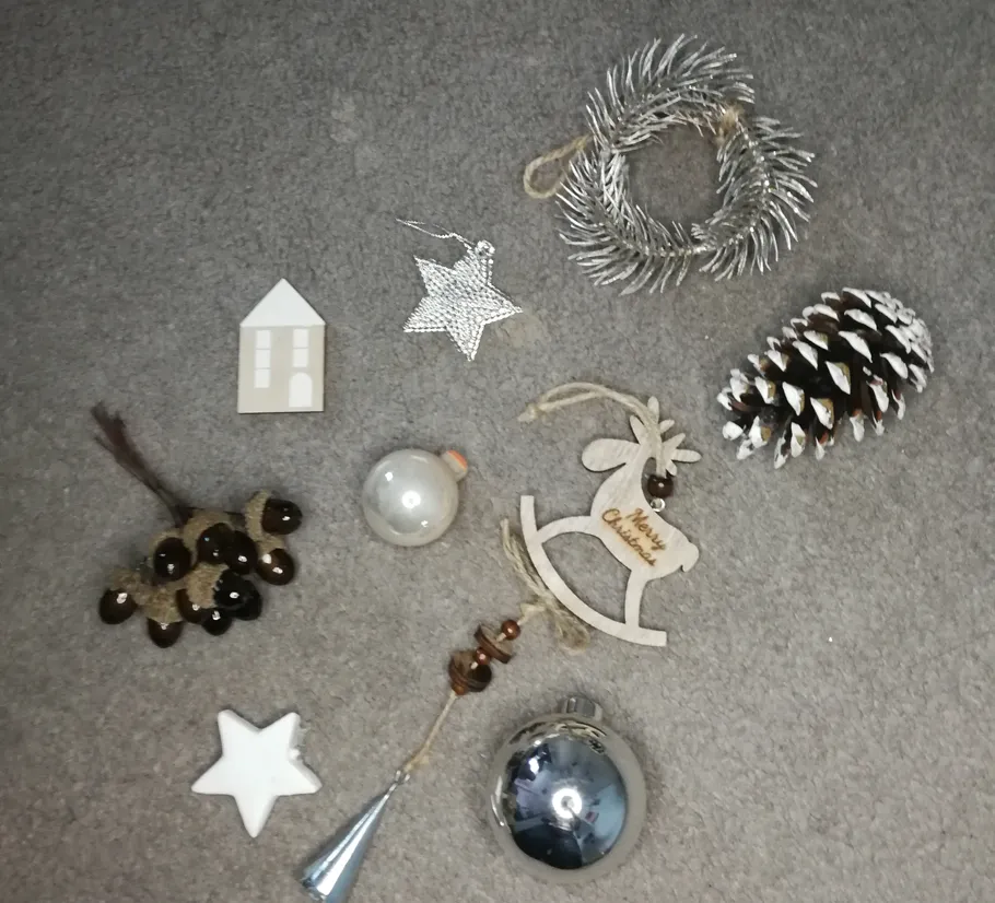 Verschiedene Weihnachtsdekorationen auf grauem Teppich.