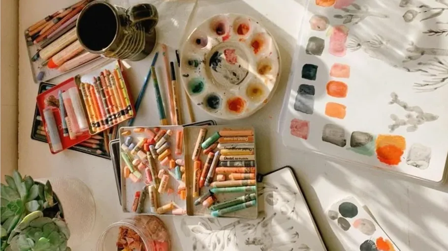 Art supplies and sketches on a table.