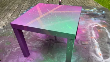 Bunt bemalter Tisch auf besprühter Plane.