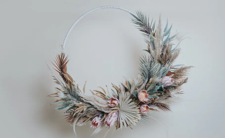 Decorative floral wreath with dried flowers displayed.