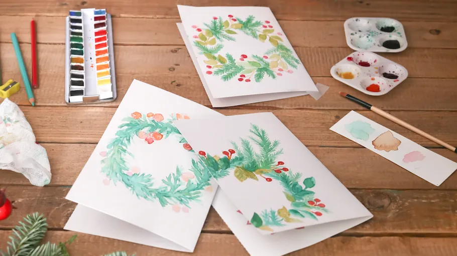 Grußkarten mit Aquarelldesigns auf Tisch.