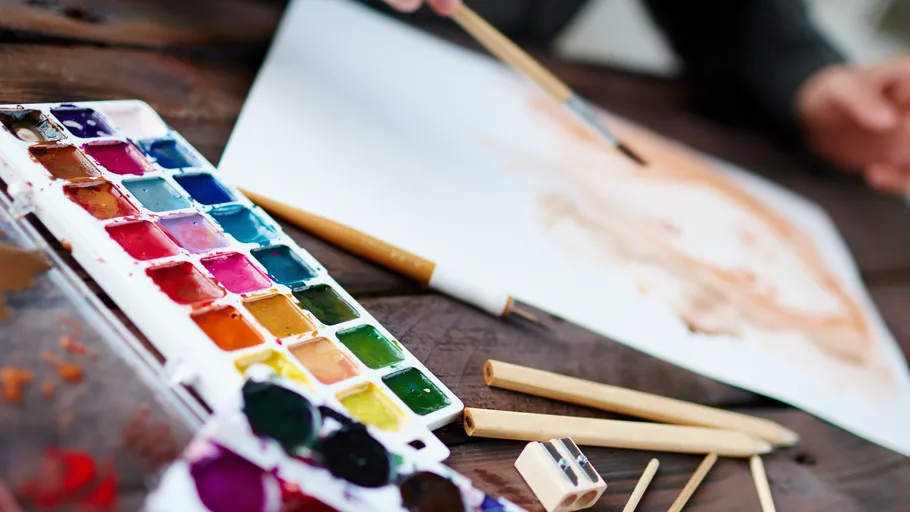 Paint set with brushes on wooden table.