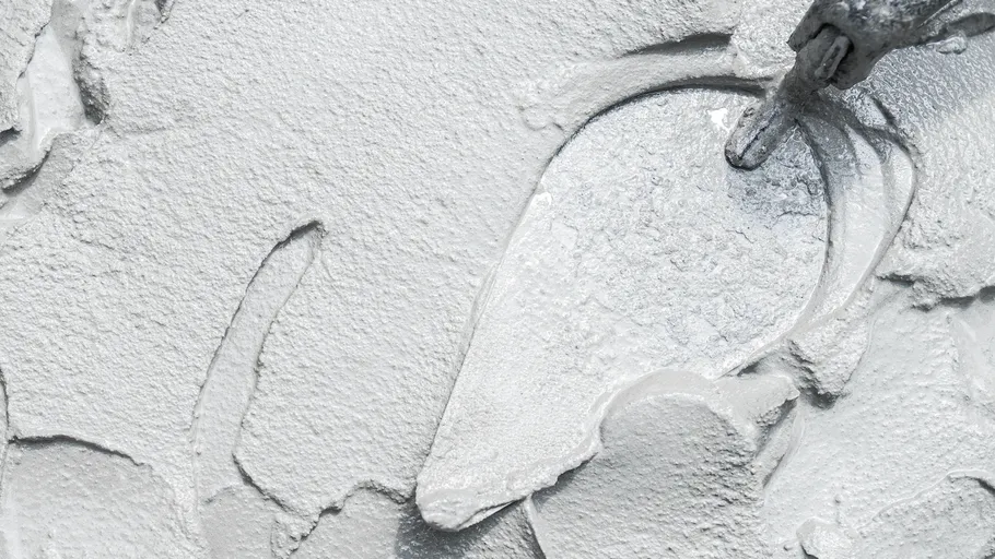 Trowel smoothing wet cement on surface.