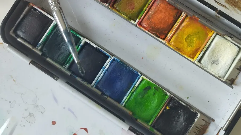 Pinsel auf Aquarellfarbpalette.