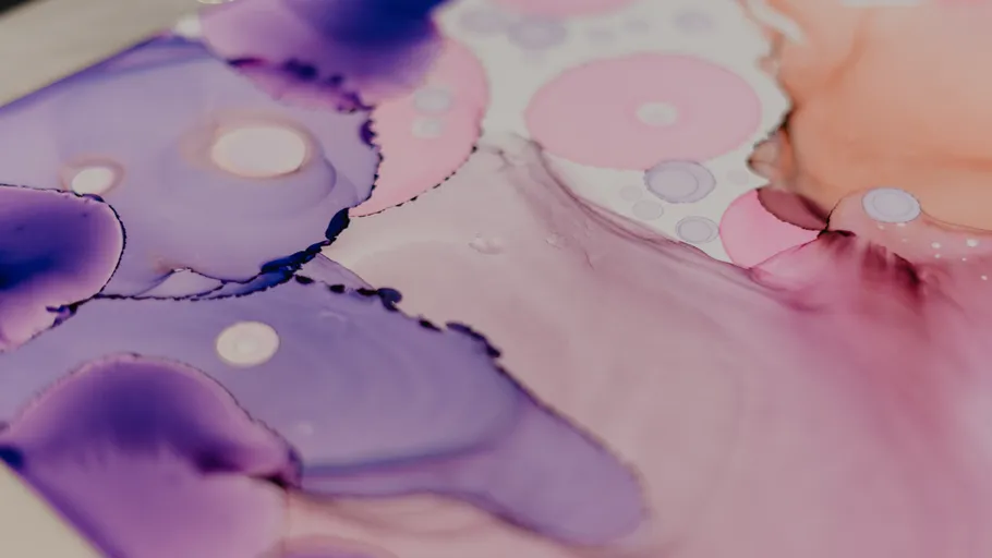 Abstract watercolor art with pink and purple hues.