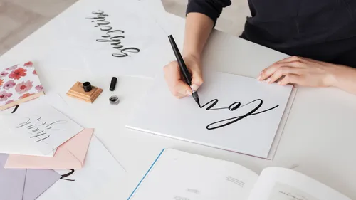 Person creating calligraphy at a desk.