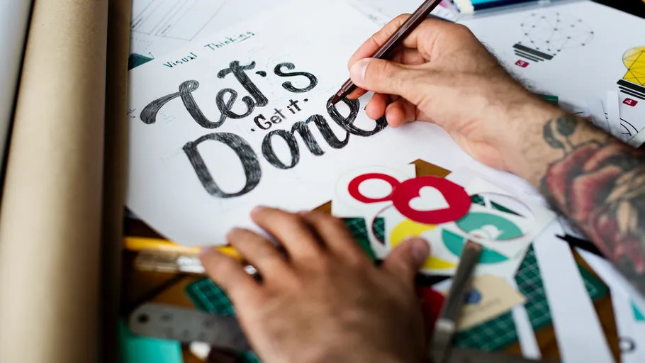 Person drawing inspirational quote design.