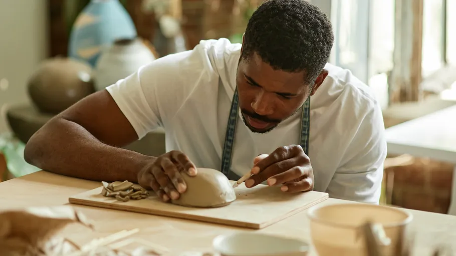 Man shaping clay in an art studio.