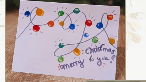Card with colorful Christmas lights, festive message.