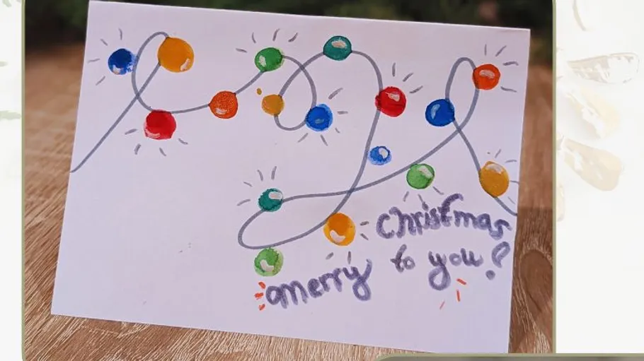 Card with colorful Christmas lights, festive message.