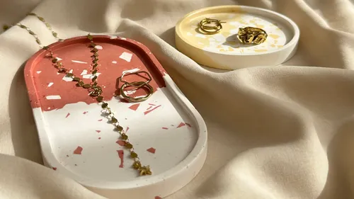 Jewelry on decorative trays on fabric.