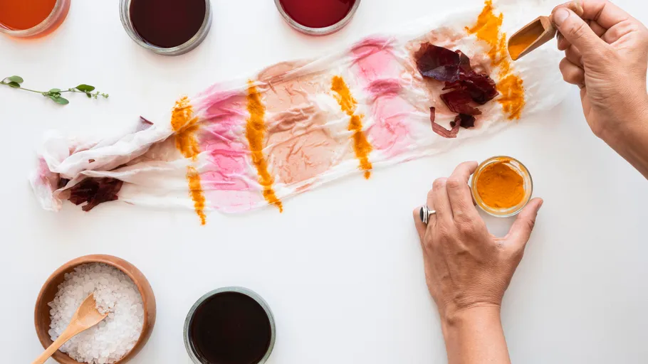 Hands dyeing fabric with natural colors.