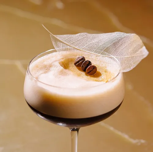 Kaffee-Cocktail mit Bohnen und Blattgarnitur.