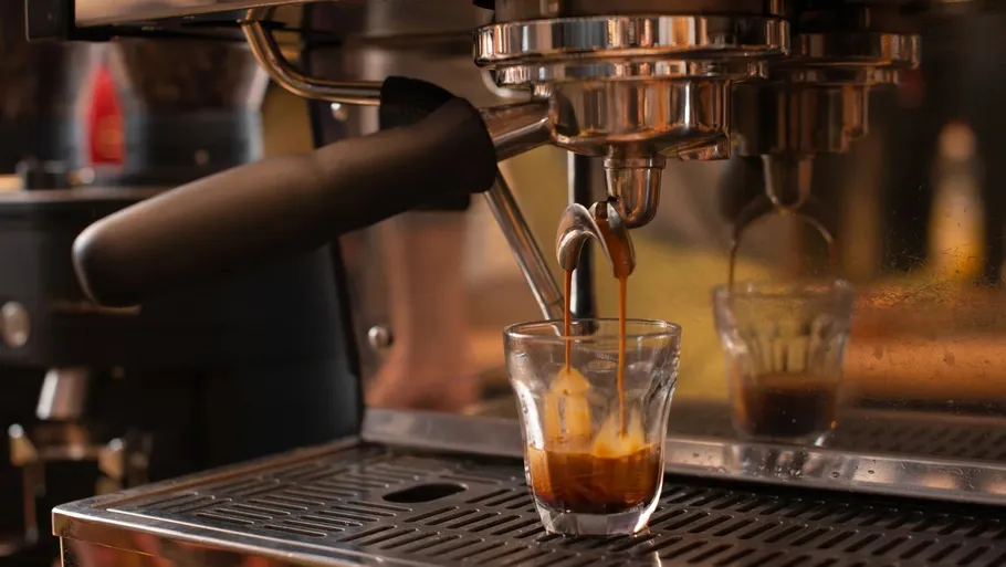 Espresso machine pouring coffee into glass.